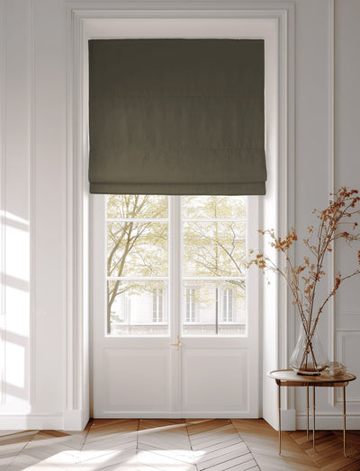 Window decorated with a dark green roman blind in cotton