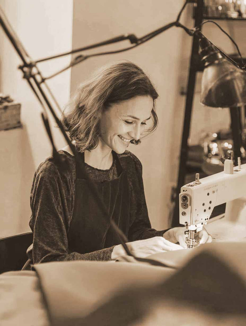 A women making made to measure bed valance of natural linen fabric for bedroom UK